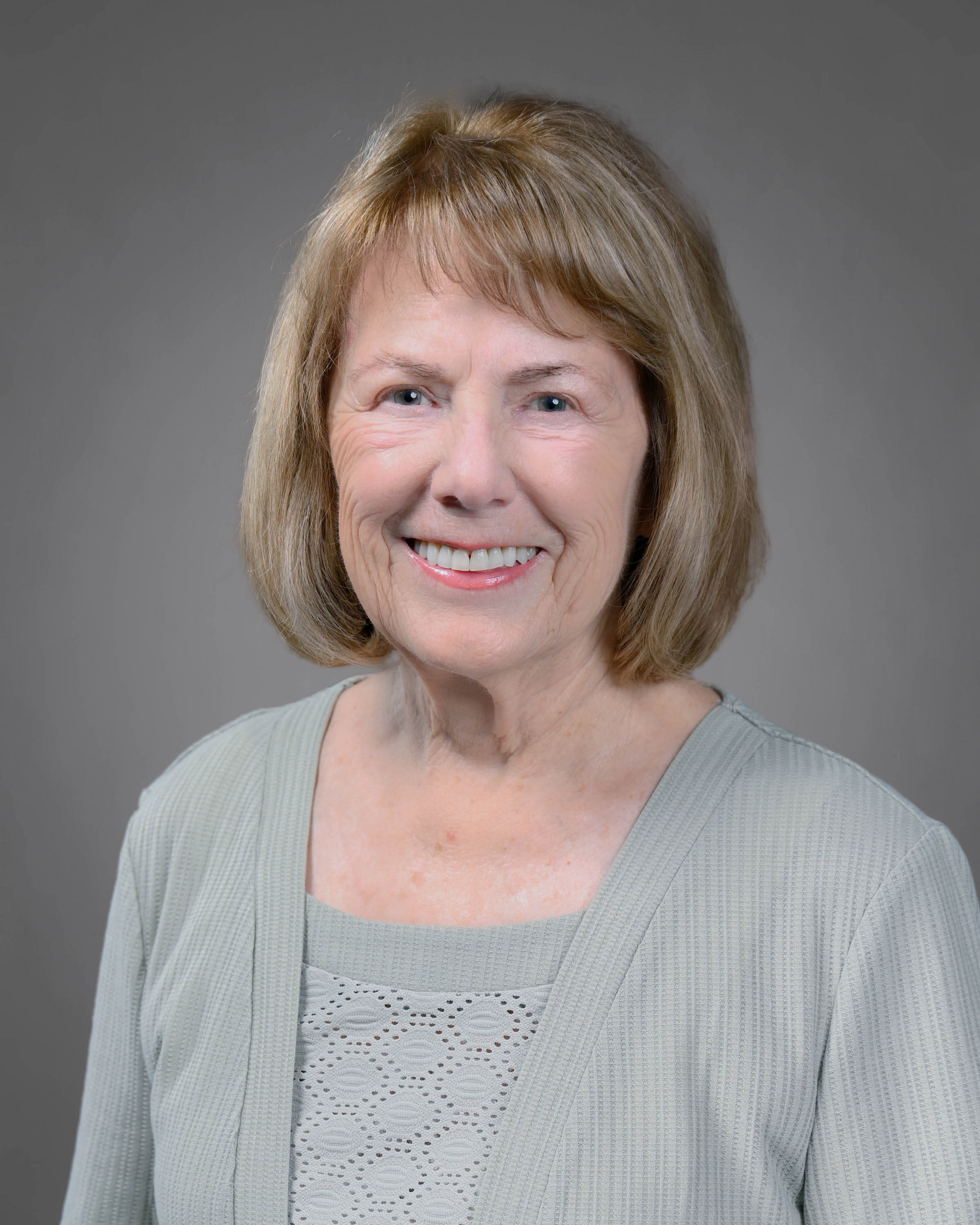 Kind woman smiling with shoulder length blonde hair